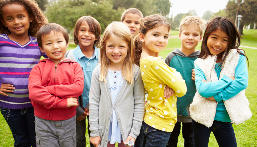 A vibrant scene of active and energetic children engaged in a variety of physical play activities. In the foreground, two young kids are enthusiastically chasing a ball, their laughter and joy palpable. In the middle ground, a group of children are climbing on a colorful jungle gym, their bodies in motion as they explore and test their physical skills. The background features a lush, verdant outdoor setting with trees and a sunny sky, conveying a sense of freedom and natural exploration. Crisp, realistic lighting illuminates the dynamic movements and expressions of the children, capturing the exhilarating and beneficial essence of active play. دراسة علمية: اللعب الحركي وفوائده الصحية للأطفال